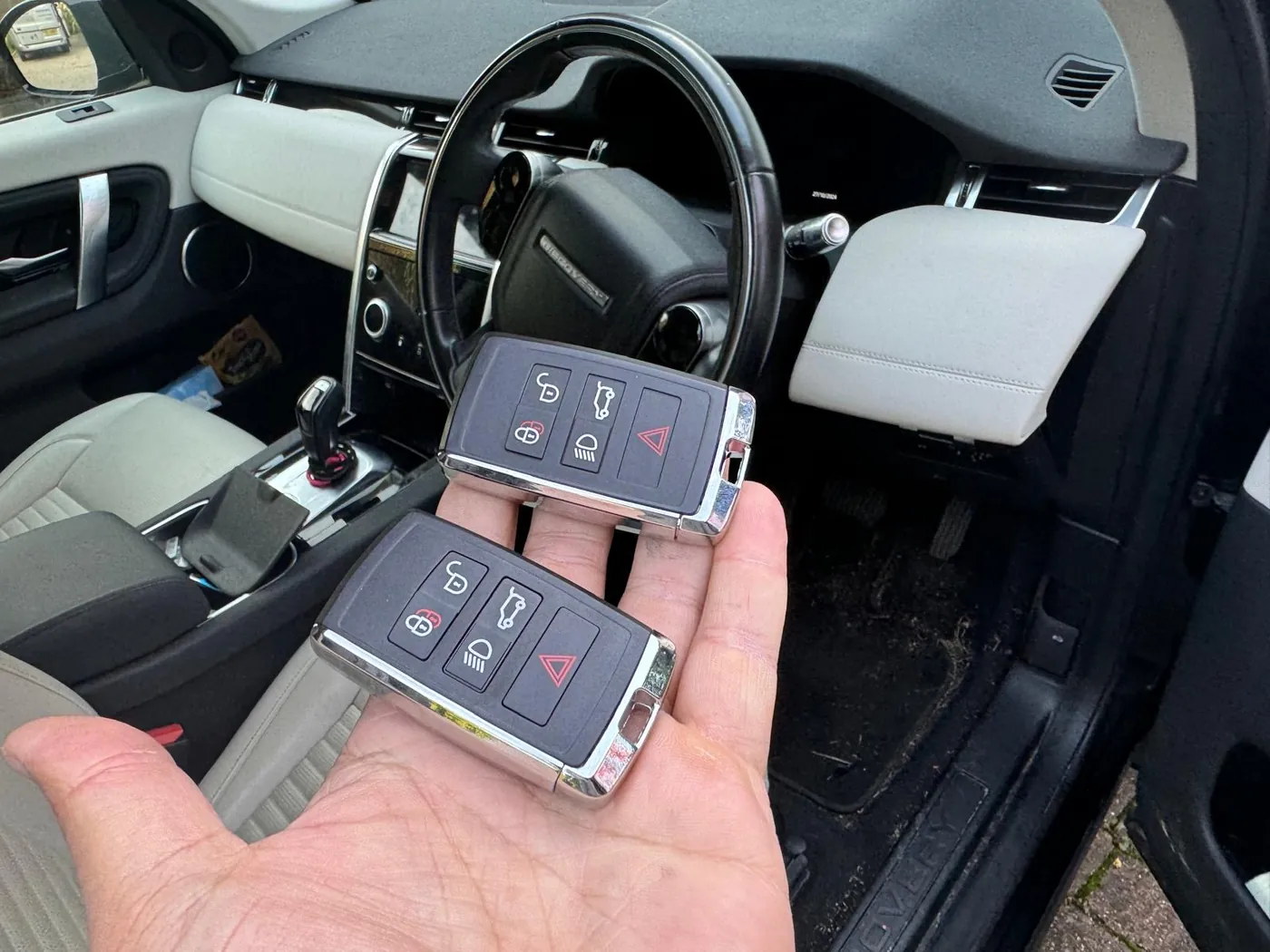 Two spare Land Rover smart keys held in hand inside the vehicle